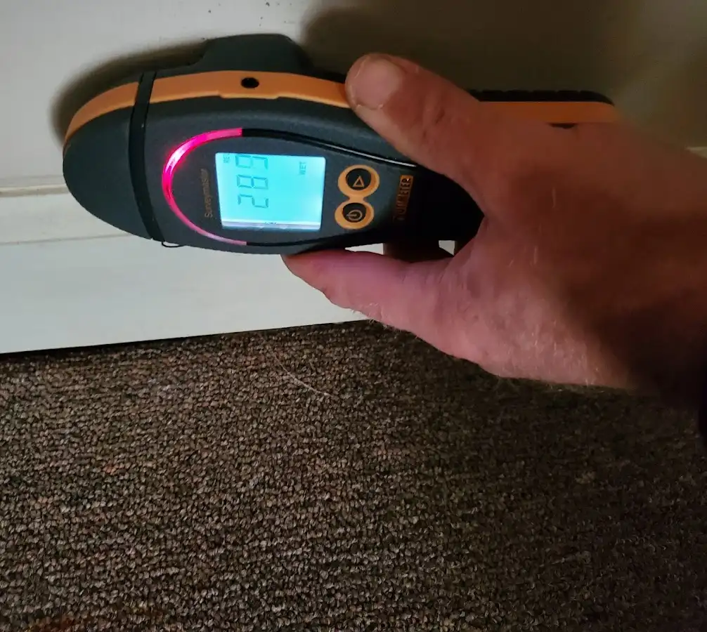 Moisture detection at baseboard during Storm Damage Restoration in Harrah